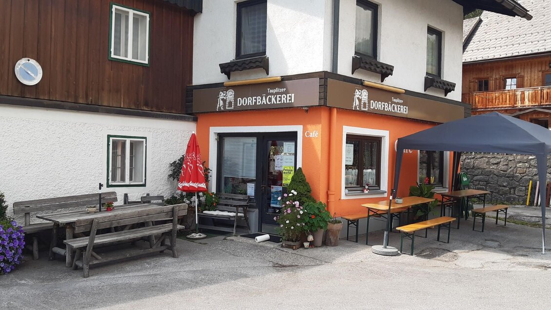 Eine charmante Bäckerei mit einer freundlichen Fassade in Orange. Es gibt draußen Tische und Bänke zum Sitzen. | © TVB Ausseerland Salzkammergut/Raunigg