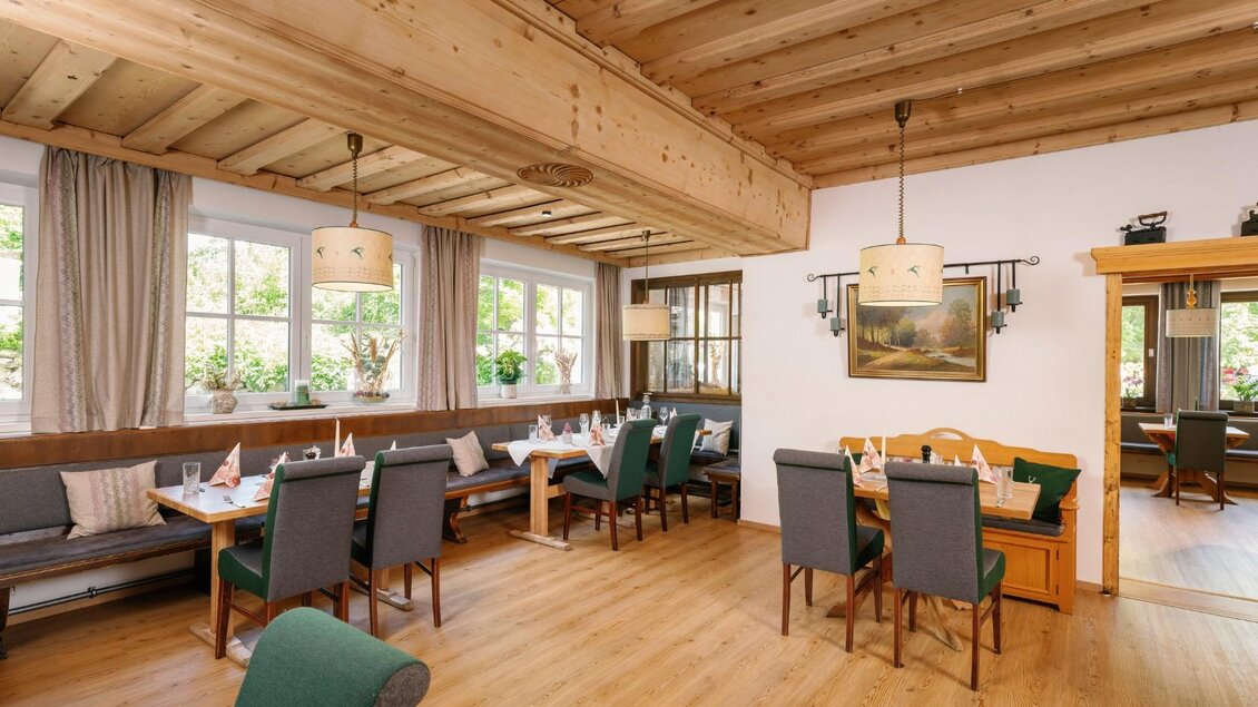 Ein gemütliches Restaurant mit Holzbalkendecke und stilvollen Möbeln. Große Fenster lassen viel Tageslicht herein und die Tische sind schön gedeckt. | © Gasthaus Stöckl