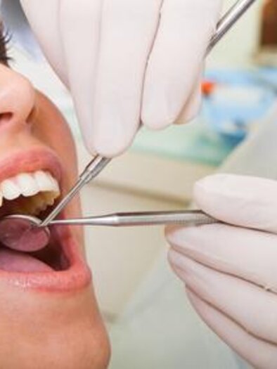 Eine Patientin wird von einem Zahnarzt untersucht. Der Zahnarzt verwendet Instrumente, um den Mund der Patientin zu überprüfen. | © Symbolfoto Fotolia