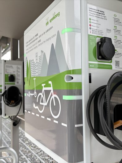 A bicycle charging station with two chargers and clear instructions. The station is located in a modern environment with a view of the mountains. | © TV Hochsteiermark