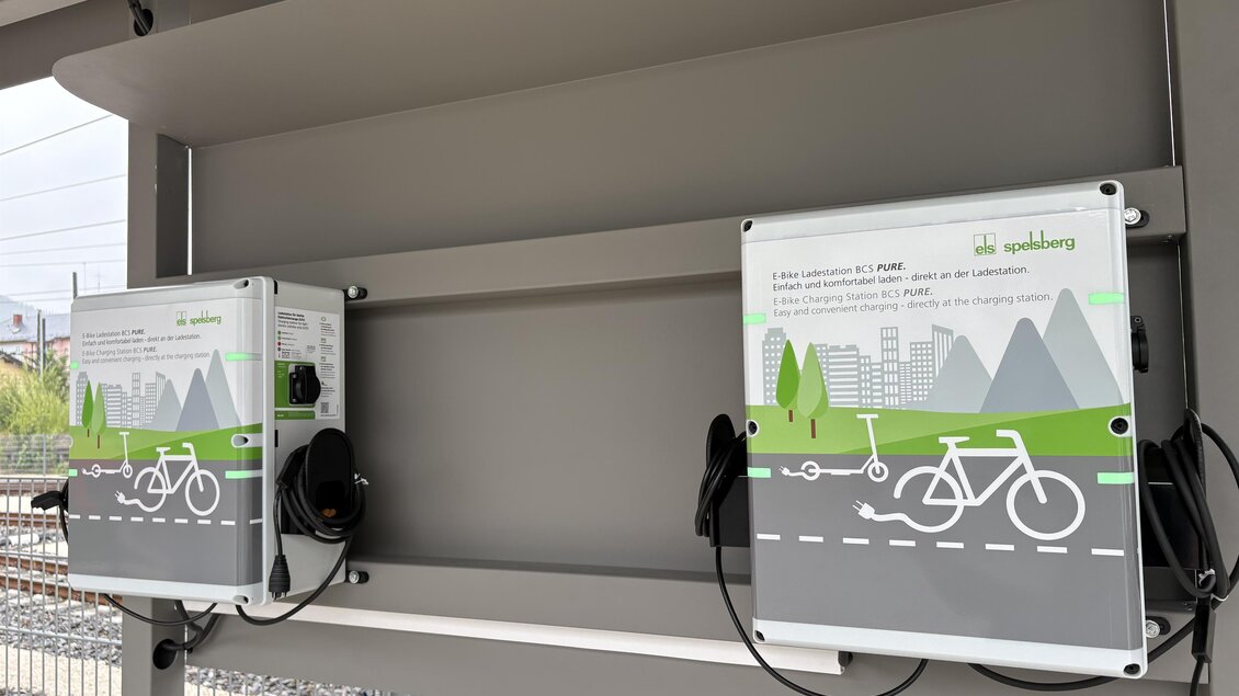 Zwei Fahrrad-Ladestationen an einem Bahnhofsunterstand. Sie sind mit Grafiken von Fahrrädern und einer Stadtlandschaft dekoriert. | © TV Hochsteiermark