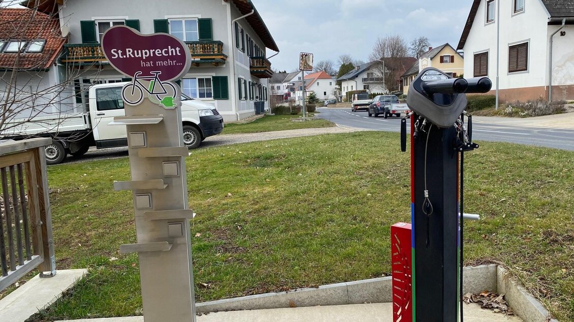 Eine Fahrradservicestation in St. Ruprecht mit Werkzeug und Luftpumpe. Im Hintergrund sind Wohnhäuser und eine Straße zu sehen. | © Oststeiermark Tourismus