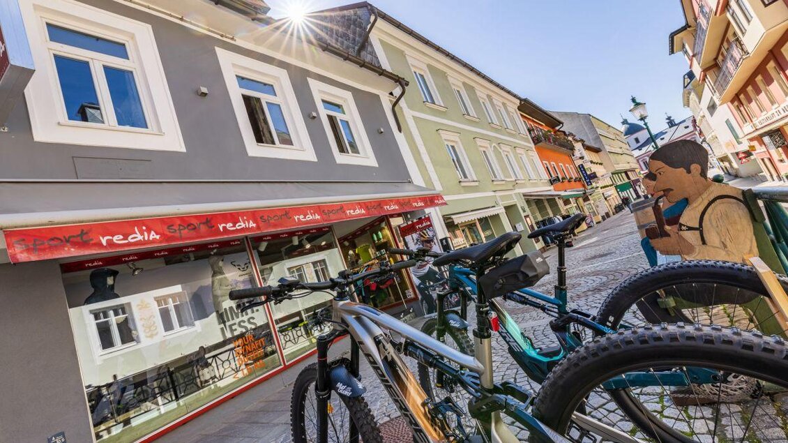 Eine belebte Straßenansicht mit mehreren Fahrrädern zum Stehen. Im Hintergrund sind farbenfrohe Gebäude und ein Café zu sehen. | © www.sportredia.at