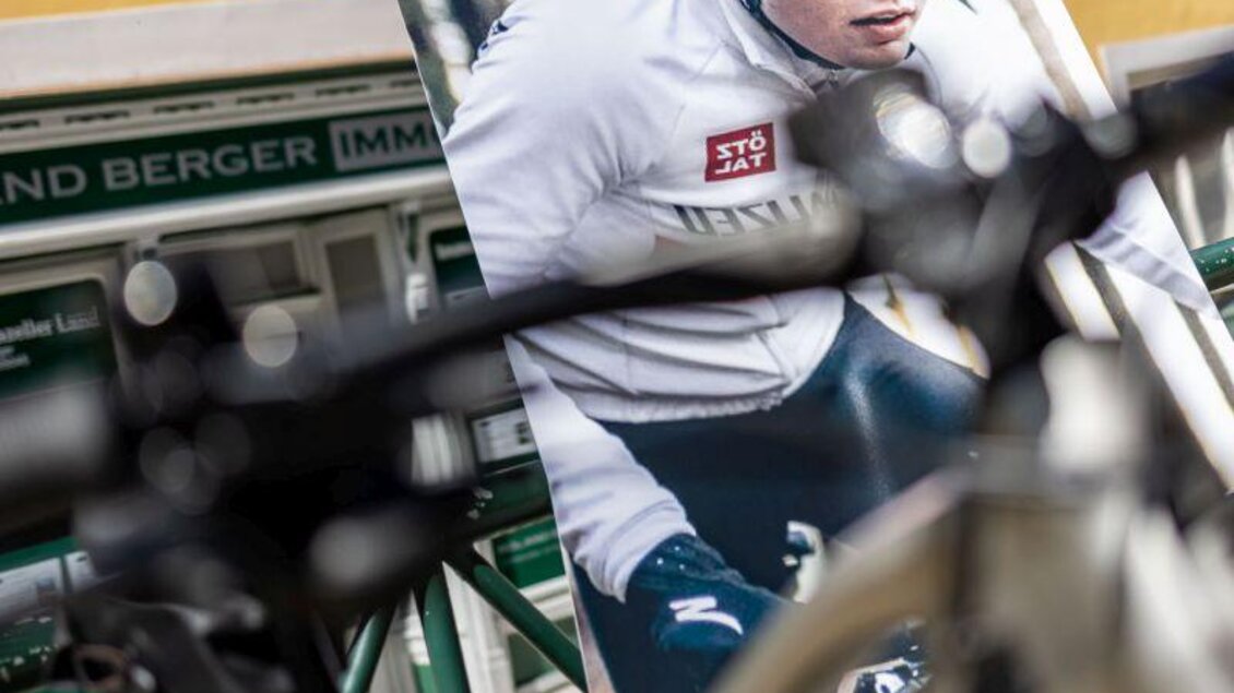 Ein Werbeschild von Sport Media zeigt einen Radfahrer in action. Im Vordergrund ist ein Fahrradrahmen zu sehen. | © www.sportredia.at