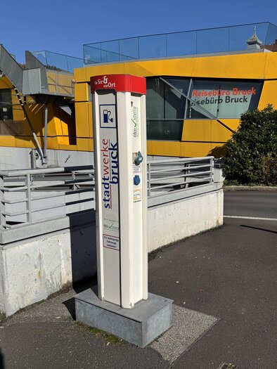 A parking meter in an urban environment. In the background, a yellow building can be seen. | © TV Hochsteiermark