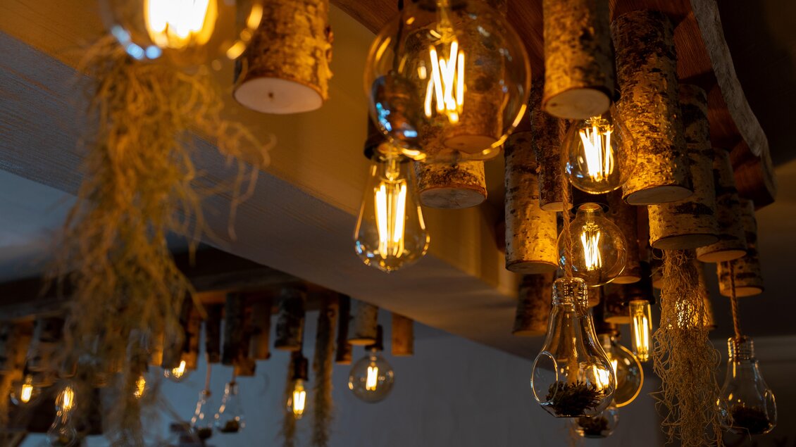 Eine moderne Beleuchtung mit Holzdetails und Edison-Lampen. Die warmen Lichter schaffen eine gemütliche Atmosphäre. | © KSF