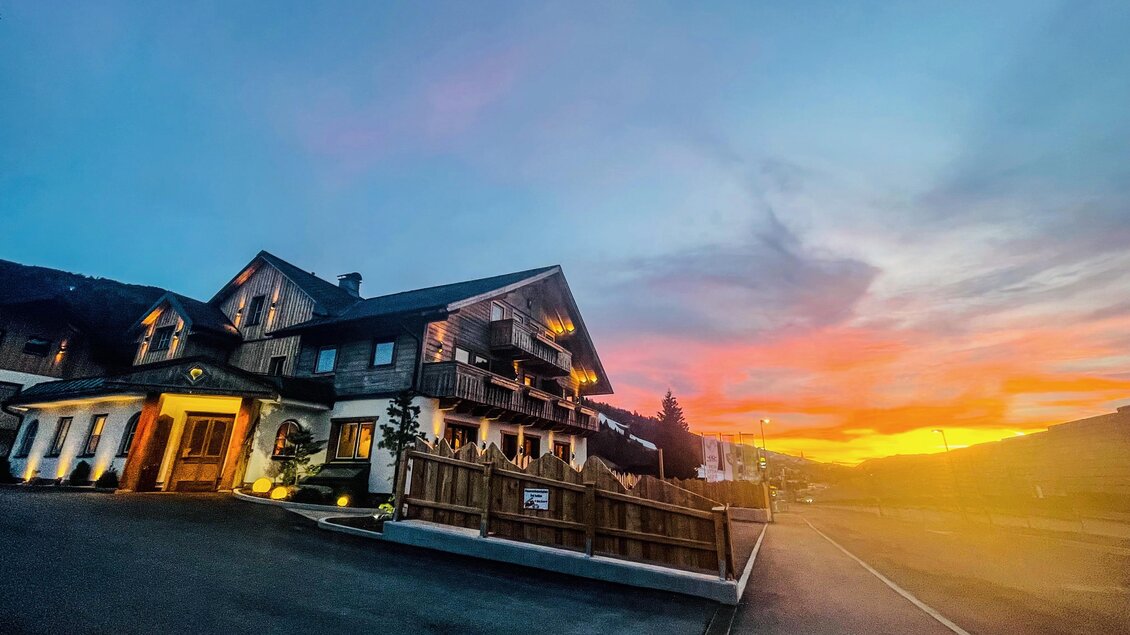 Ein gemütliches Hotel mit einem schönen Ausblick auf den Sonnenuntergang. Der Himmel ist in sanften Farben erleuchtet. | © E42