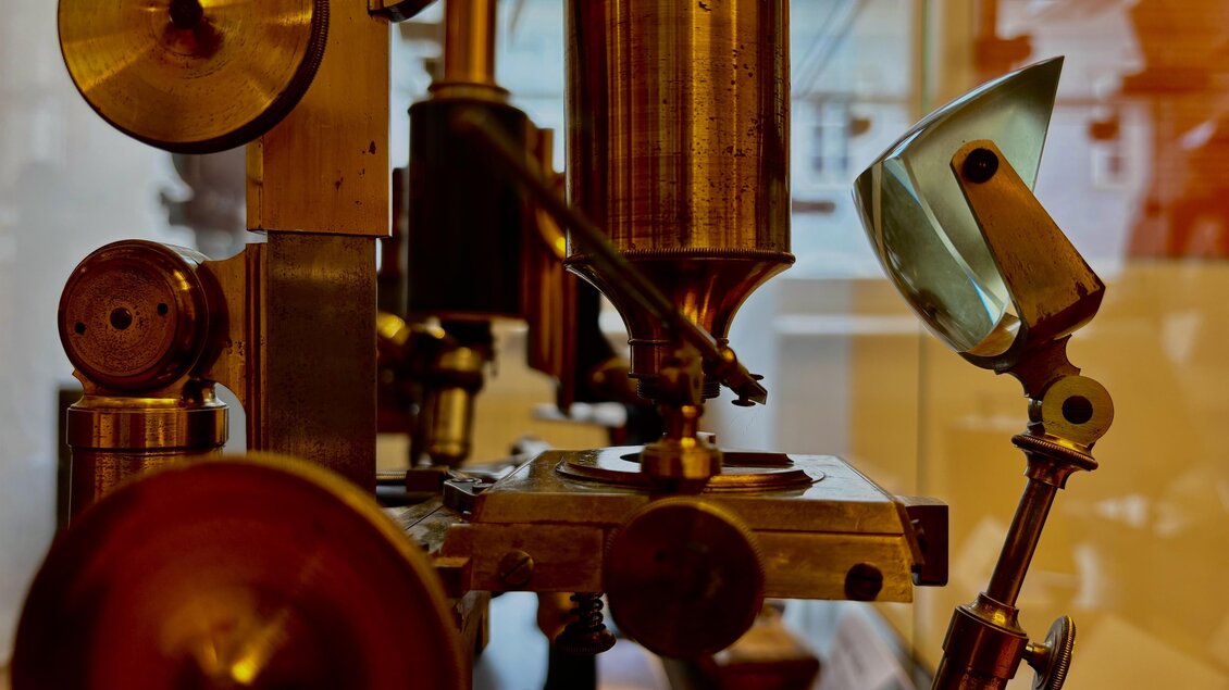 Eine detailreiche Ansicht einer alten Maschine mit metallischen Komponenten und präzisen Mechanismen. Der Fokus liegt auf verschiedenen zylindrischen und kugelförmigen Teilen. | © Echophysics