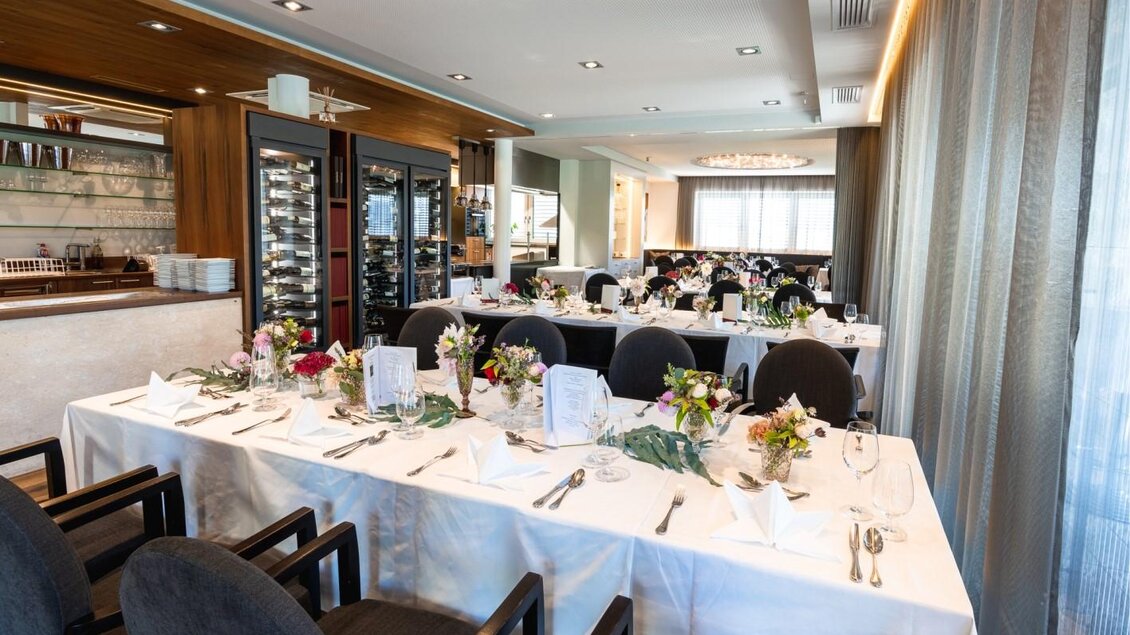 Ein eleganter Essraum mit festlich gedeckten Tischen und Blumenarrangements. Die Atmosphäre ist hell und einladend. | © Edler Landhaus Oswald
