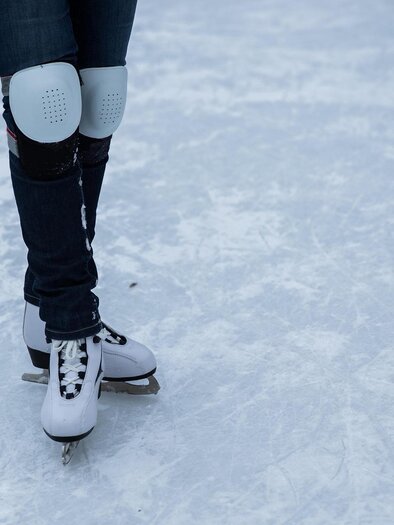An ice rink with many people happily ice skating. The sun is shining and it is winter. | © Pixabay