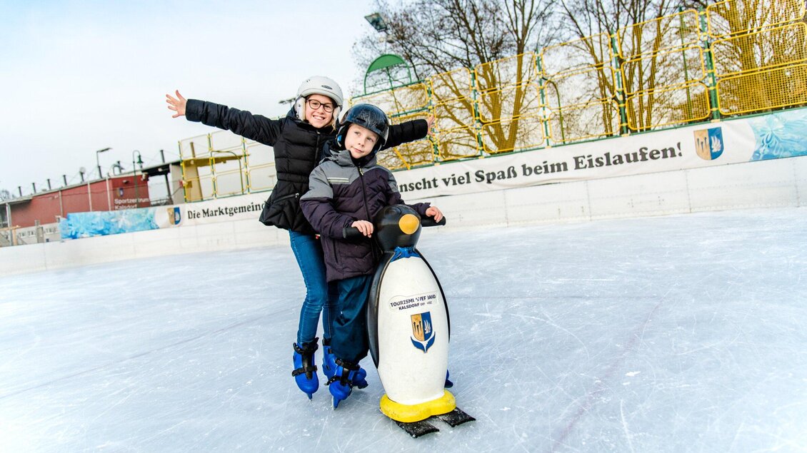 Eine Frau und ein Junge auf einer Eisbahn, die gemeinsam Spaß haben. Der Junge nutzt ein Eislauf-Hilfsgerät in Form eines Pinguins. | © TV Kalsdorf - Mias Photoart6