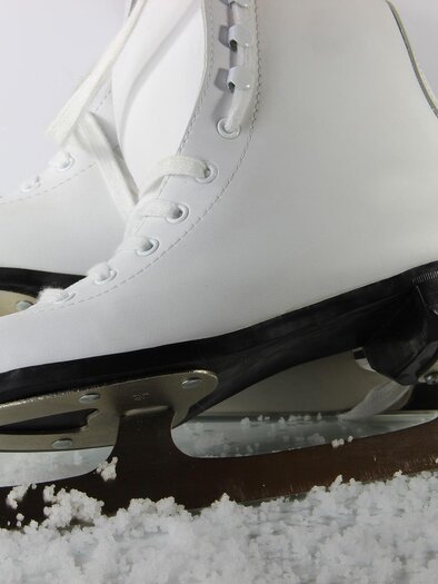 Ice stock with white skates on a snow-covered surface. The blades are shiny and ready for the ice. | © Pixabay
