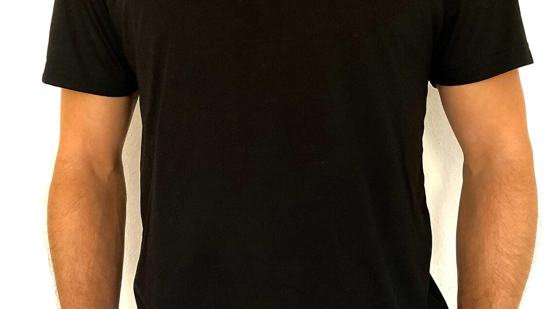 Ein schwarzes T-Shirt mit dem Logo "EISLEDER" auf der linken Brustseite. Der Träger steht aufrecht und trägt dazu eine helle Jeans. | © Eisleder Bergzeig