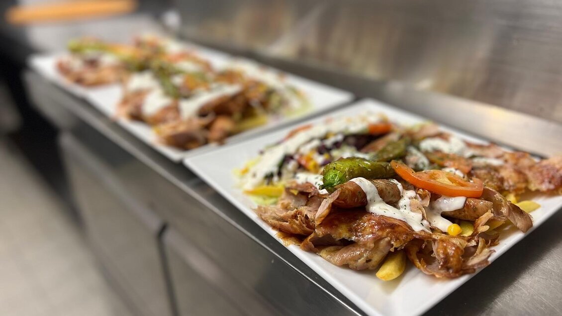 Zwei Teller mit köstlichem Essen, garniert mit frischem Gemüse und Soße. Die Gerichte bestehen aus Fleisch und Beilagen, ideal für ein herzhaftes Mahl.