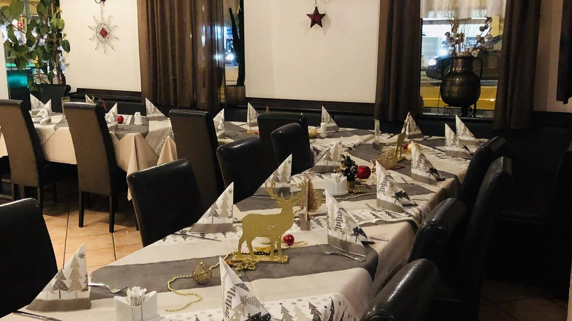 Ein einladendes Restaurant mit schön gedeckten Tischen. Die Dekoration ist festlich mit weißen Servietten und Weihnachtsmotiven. | © EL Paso