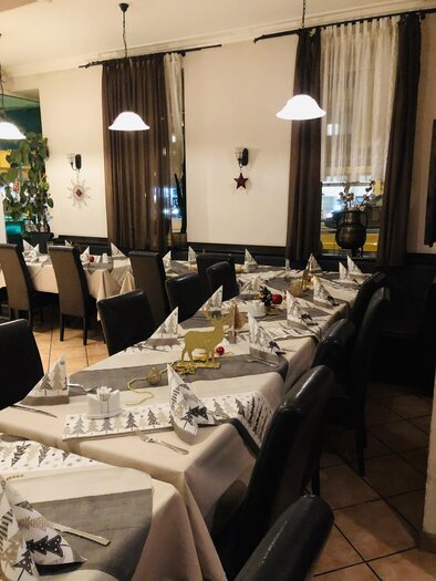 Ein einladendes Restaurant mit schön gedeckten Tischen. Die Dekoration ist festlich mit weißen Servietten und Weihnachtsmotiven. | © EL Paso