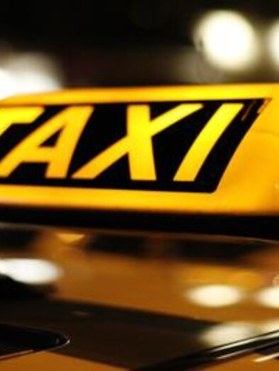 Ein Taxi-Schild mit leuchtenden Buchstaben. Es ist Nacht, und der Hintergrund ist unscharf. | © Fotolia