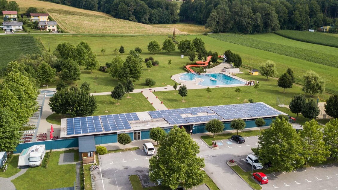 Ein großer Außenbereich mit einem Schwimmbad und grünen Rasenflächen. In der Nähe befinden sich Bäume und Parkplätze, ideal für Familienausflüge. | © Netwerker