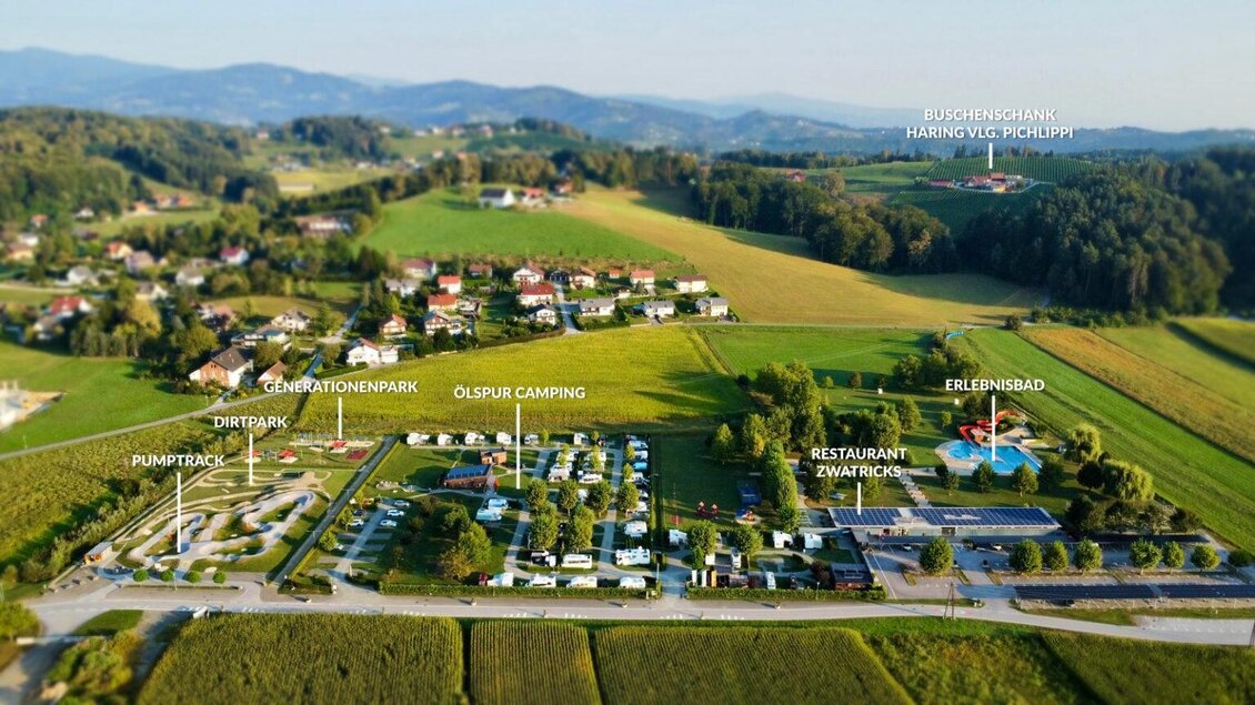 Eine Übersichtskarte eines Campingplatzes mit einem Erlebnisbad, Restaurant und verschiedenen Stellplätzen in einer grünen Umgebung. Die Landschaft bietet hügelige Felder und kleine Wohnsiedlungen im Hintergrund. | © Gregor Moser