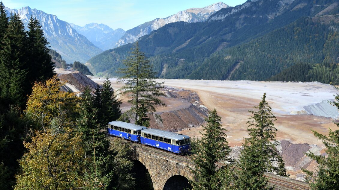Eine alte Zugbrücke umgeben von Bergen und Wald. Der Zug fährt durch eine malerische Landschaft mit einer klaren Aussicht. | © Mathias Danner