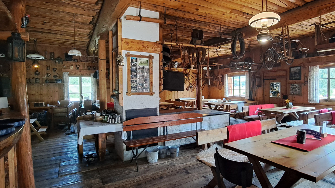 Ein gemütliches Restaurant mit Holzwänden und rustikalen Möbeln. Die Einrichtung umfasst nostalgische Gegenstände und bietet eine einladende Atmosphäre. | © Eselalm