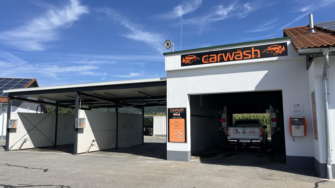 Eine Autowaschanlage mit einem modernen Gebäude und Parkplatz. Der Himmel ist klar und blau. | © Peter Hopf