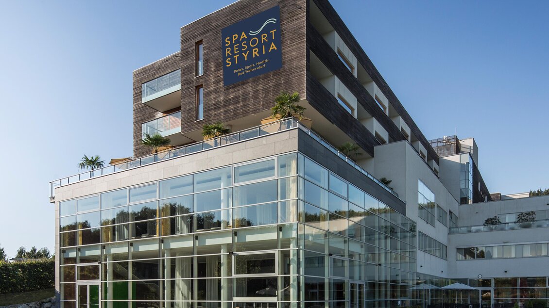 Ein modernes Spa-Resort mit großen Glasfenstern und einem klaren Pool. Die Architektur ist zeitgemäß und stilvoll. | © Spa Resort Styria