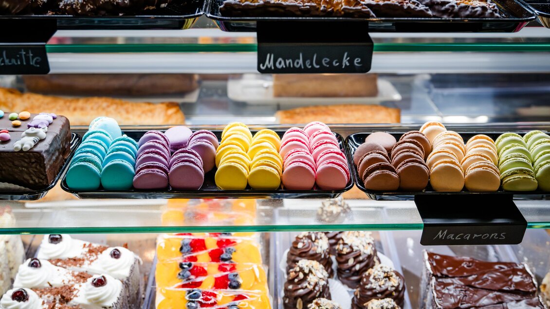 Eine Auswahl an bunten Macarons und verschiedenen Kuchen in einer Vitrine. Die Leckereien sind ansprechend angerichtet und verleiten zum Probieren. | © Region Graz - Mias Photoart