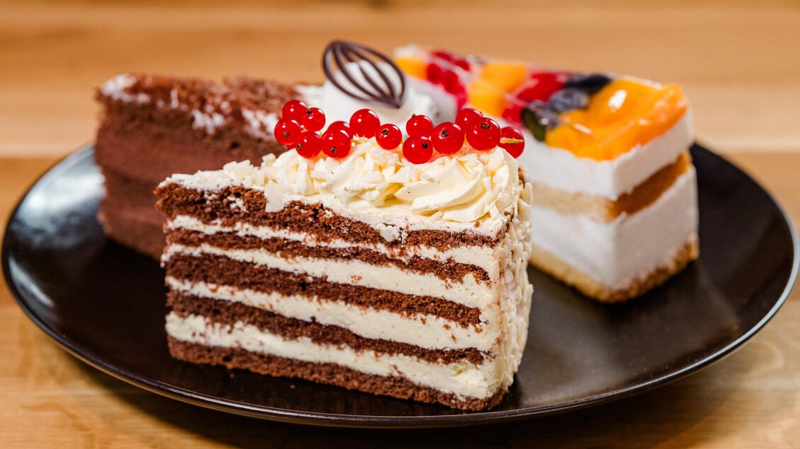 Ein Teller mit drei verschiedenen Kuchenstücken. Darunter ein Schokoladenkuchen mit Sahne, ein fruchtiger Sahnekuchen und ein Biskuitkuchen. | © Region Graz - Mias Photoart