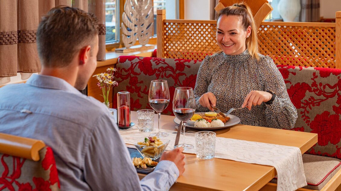Ein romantisches Dinner in einem gemütlichen Restaurant. Ein Paar genießt köstliches Essen und Wein zusammen. | © Christine Höflehner