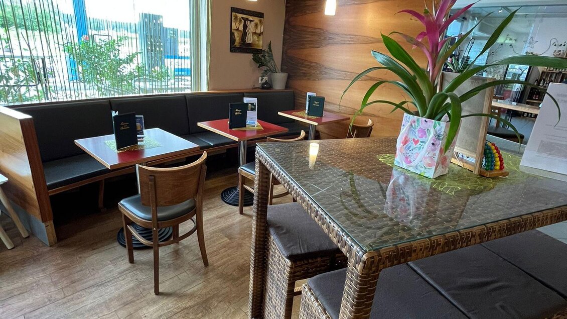 Ein gemütliches Café mit Holzböden und großen Fenstern. Tische mit Stühlen und Pflanzen sorgen für eine einladende Atmosphäre. | © Bettina Fiedler