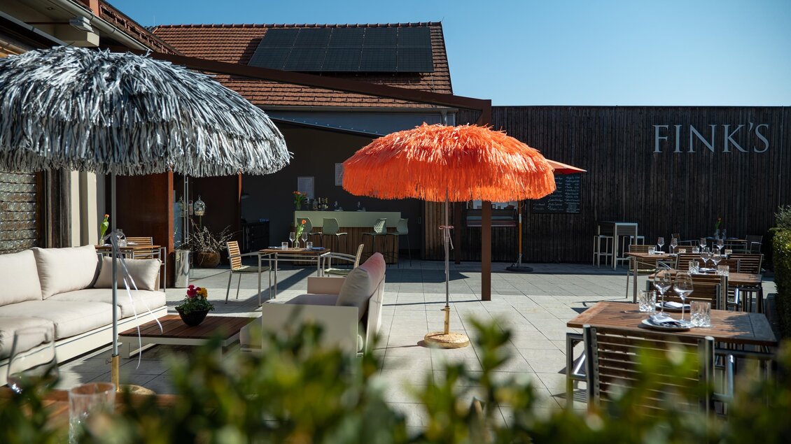 Eine gemütliche Terrasse mit bunten Sonnenschirmen und stilvollen Möbeln. Der Himmel ist klar und die Atmosphäre ist einladend. | © Bernhard Bergmann