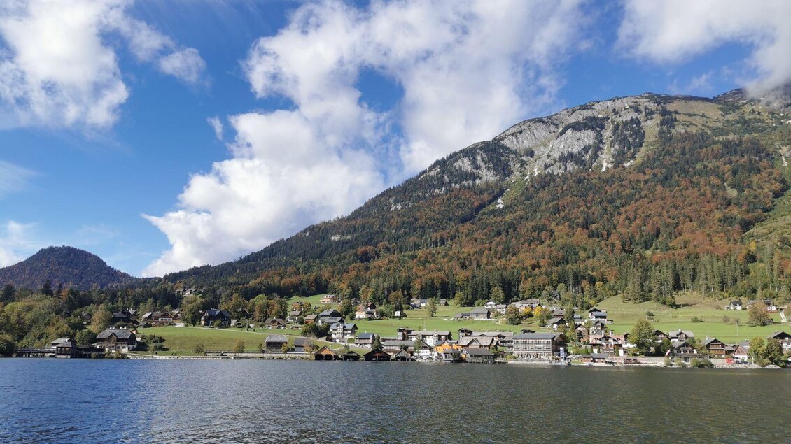 Ein ruhiger See umgeben von einer malerischen Landschaft. Im Hintergrund erheben sich grüne Berge und Wolken am blauen Himmel. | © TVB Ausseerland Salzkammergut_Theresa Schwaiger