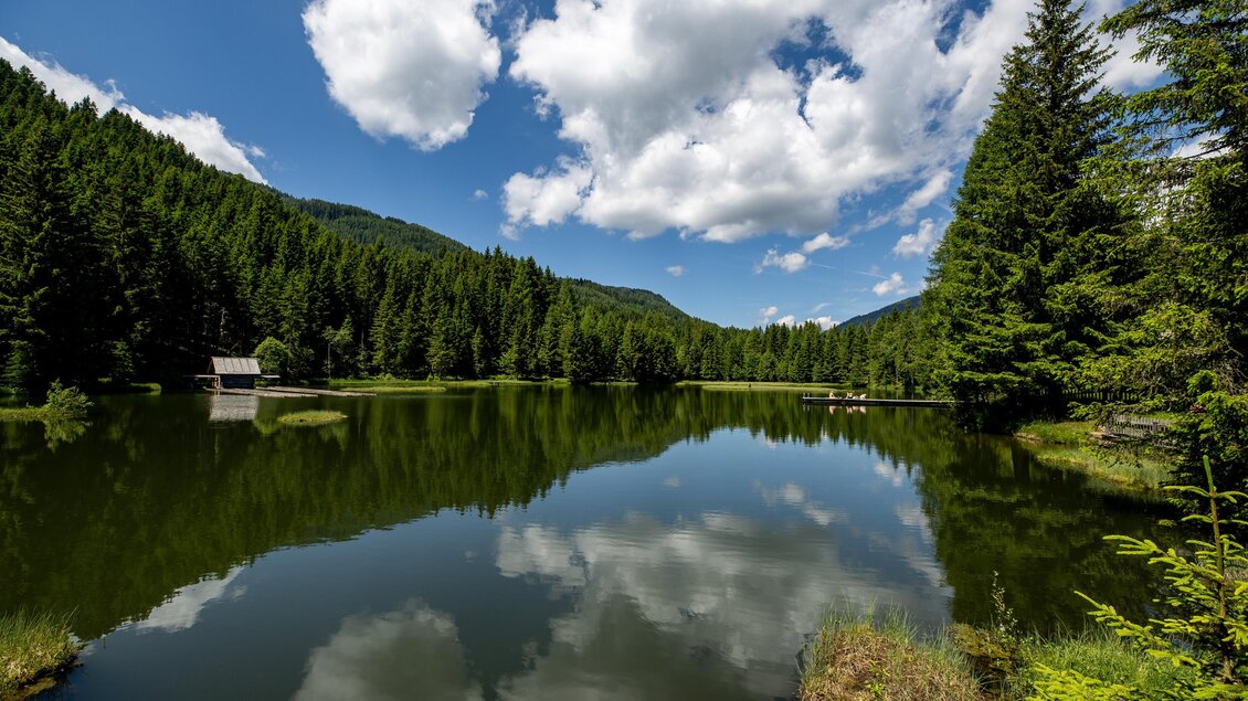 Ein ruhiger See umgeben von hohen Tannen und sanften Hügeln. Der klare Himmel spiegelt sich in der Wasseroberfläche wider. | © TVB Murau