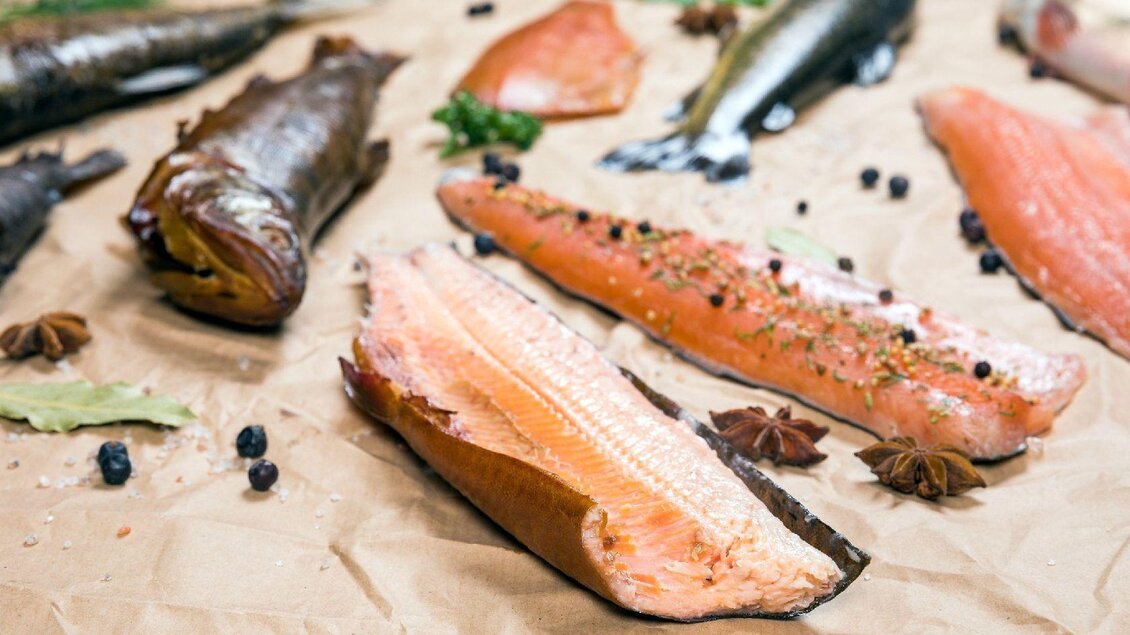 Eine Auswahl an verschiedenen Fischfilets auf braunem Papier. Die Produkte sind frisch und einige sind mit Gewürzen dekoriert. | © Fischerei Ausseerland/Martin Huber