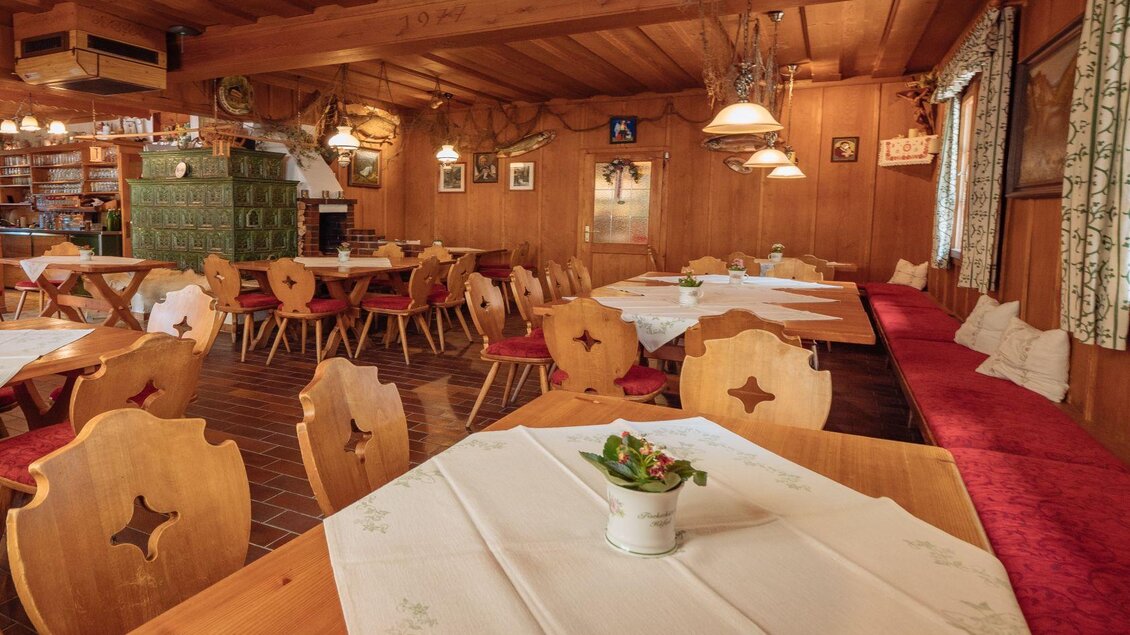 Ein einladendes Restaurant mit Holzmöbeln und rustikalem Dekor. Tische sind für Gäste vorbereitet, und das Ambiente wirkt gemütlich und traditionell. | © Andreas Syen