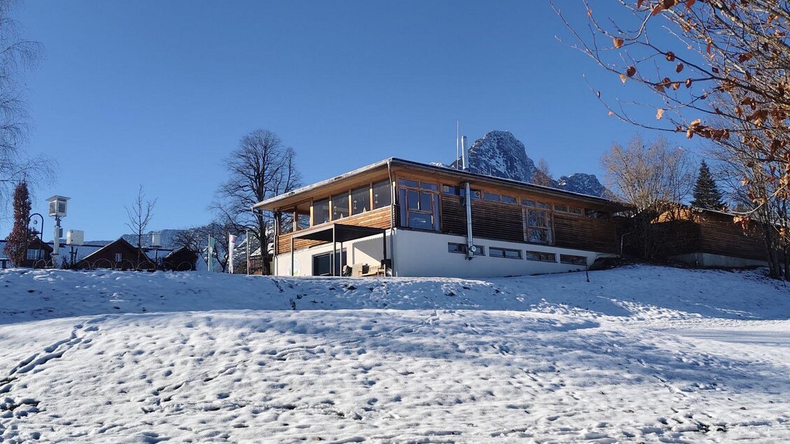 Ein modernes Holzhaus in einer verschneiten Landschaft. Der klare blaue Himmel bildet einen schönen Kontrast zur winterlichen Umgebung. | © Elisabeth Pichler