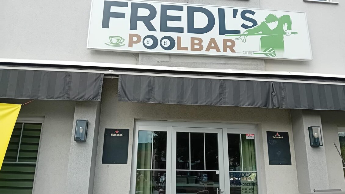 Eingang von Fredl’s Poolbar in Voitsberg mit Werbeschild und Markise. | © Fredl`s Poolbar