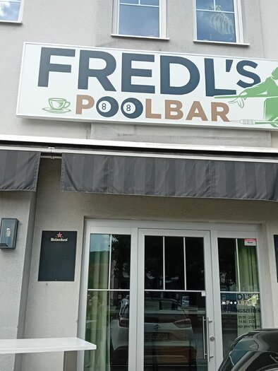 Eingang von Fredl’s Poolbar in Voitsberg mit Werbeschild und Markise. | © Fredl`s Poolbar