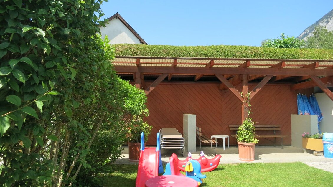 Ein schöner Garten mit Spielgeräten für Kinder. Im Hintergrund sind eine überdachte Terrasse und viel Grün zu sehen. | © Gemeinde Mitterberg-Sankt Martin 