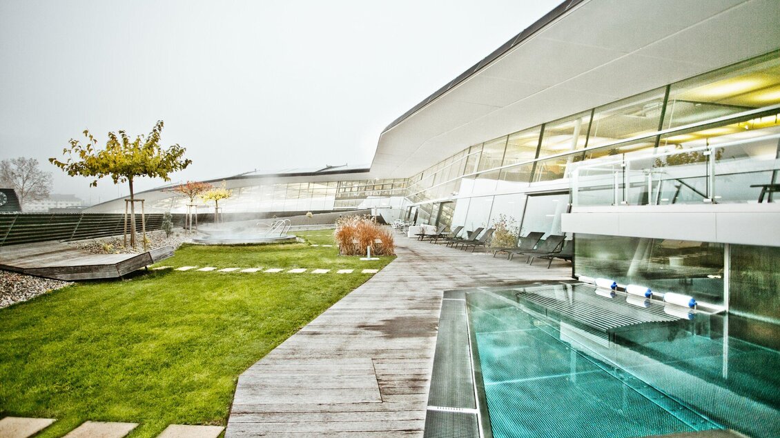 Ein moderner Architekturkomplex mit großen Fenstern und einem eleganten Poolbereich. Der Garten ist gepflegt und bietet eine entspannende Atmosphäre. | © Holding Graz - Lupi Spuma