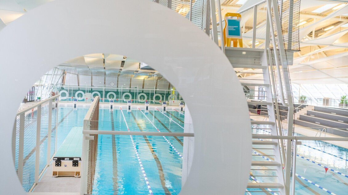 Blick durch runde Glasöffnung auf das Sportbecken der Auster Graz | © Holding Graz - achtzigzehn