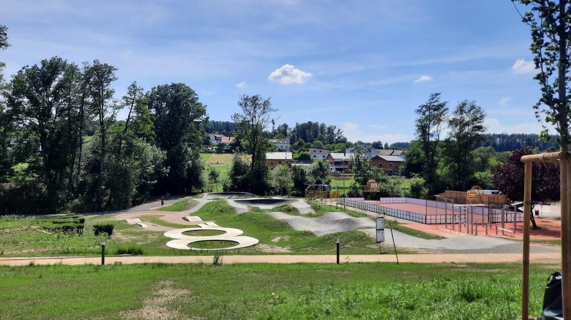 Ein schöner Park mit einem Wasserspielplatz und Sportanlagen. Im Hintergrund sind Bäume und eine hügelige Landschaft zu sehen. | © Marktgemeinde Pischelsdorf