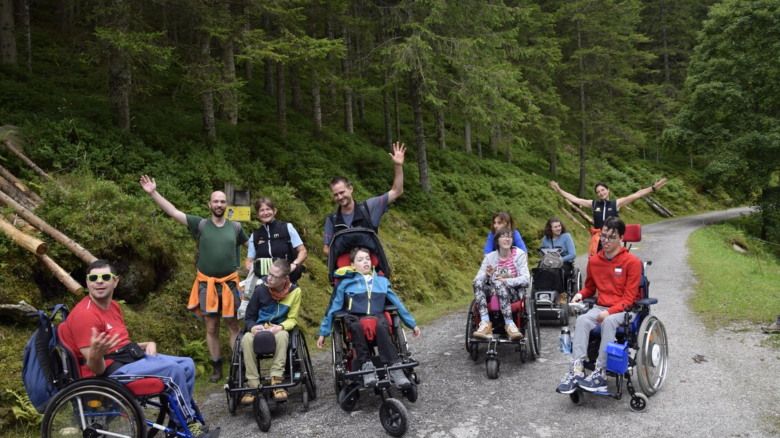 Eine Gruppe von Menschen in Rollstühlen genießt die Natur auf einem Waldweg. Freunde und Familie scheinen fröhlich und aktiv zu sein. | © Freizeit-PSO