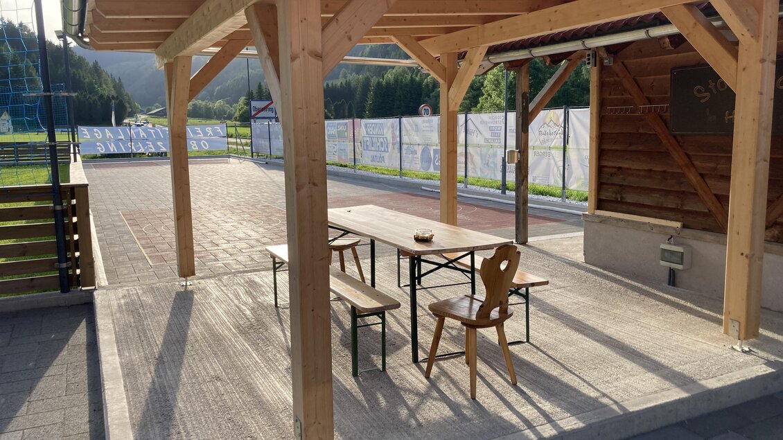 Ein überdachter Außenbereich mit einem Tisch und Stühlen. Im Hintergrund ist eine schöne Landschaft zu sehen. | © Jürgen Strohmeyer