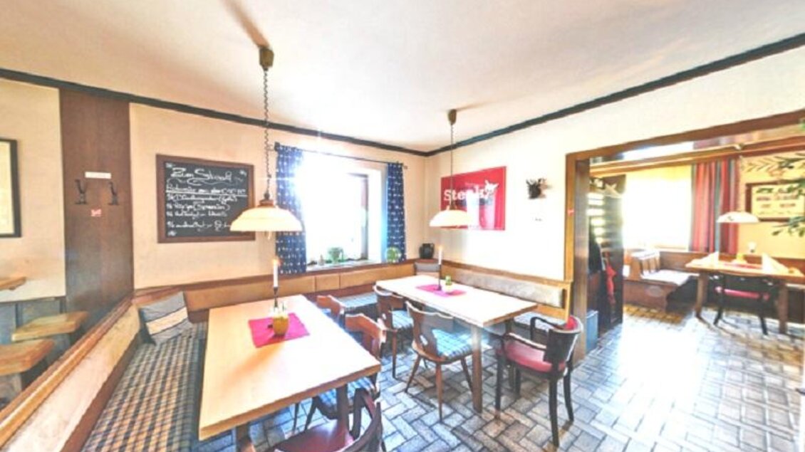 Ein gemütliches Restaurant mit Holzstühlen und Tischen. Die Wände sind mit dekorativen Elementen und Beleuchtung ausgestattet. | © keine Kenntnis