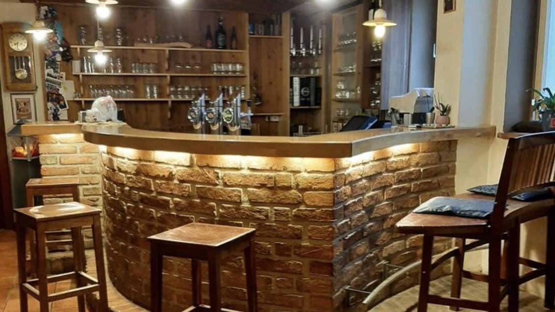 Eine elegante Bar mit einem gemauerten Tresen und Holzregalen. Es gibt einige Hocker und eine gemütliche Atmosphäre. | © Gasthaus Ägydi