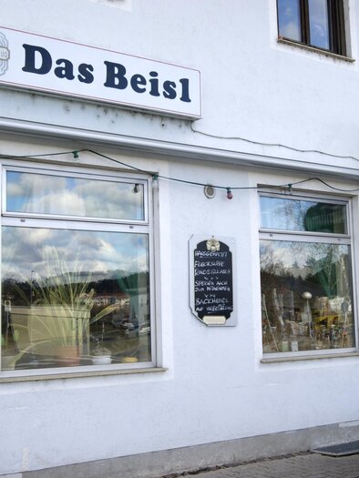 Ein Restaurant mit dem Namen "Das Beisl" ist an einer weißen Wand zu sehen. Die Fenster sind gut sichtbar und es gibt eine kleine Tafel neben dem Eingang. | © Gemeinde Gratkorn - Gasser