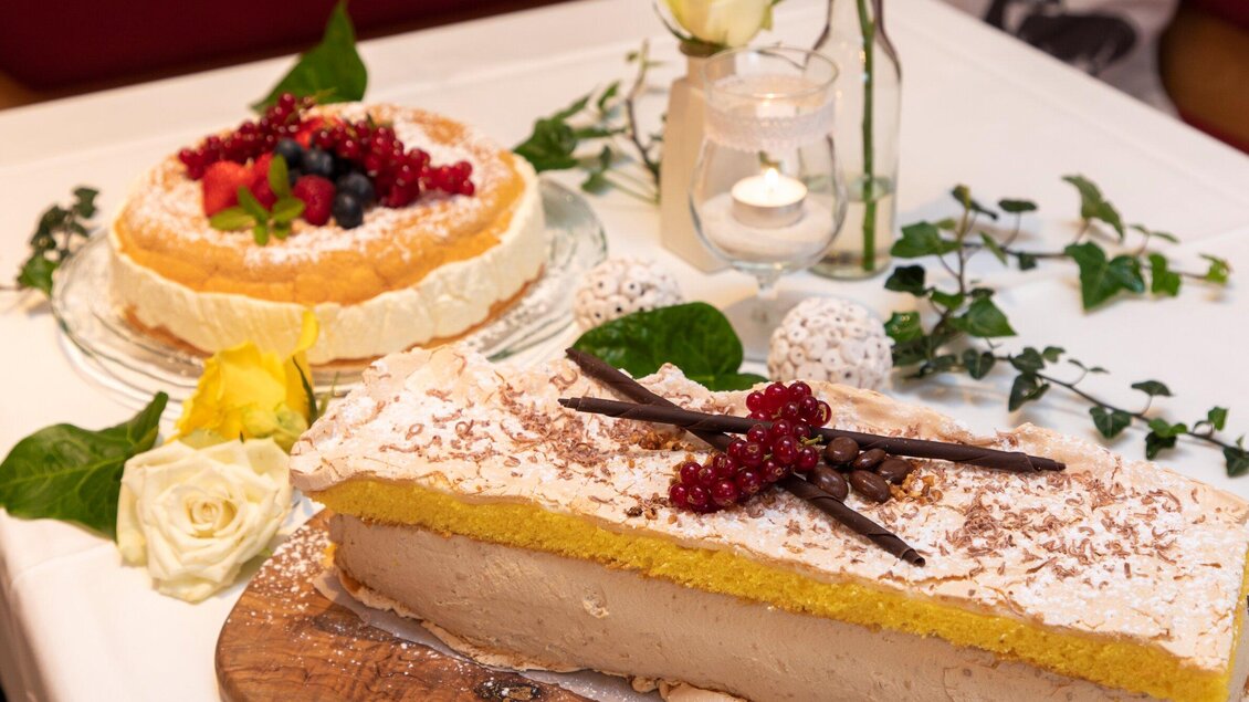 Zwei köstliche Torten auf einem Tisch. Eine Torte ist mit Früchten dekoriert, die andere hat eine gelbe Unterlage und ist mit Schokolade und Beeren verziert. | © TV Region Graz - Lunghammer