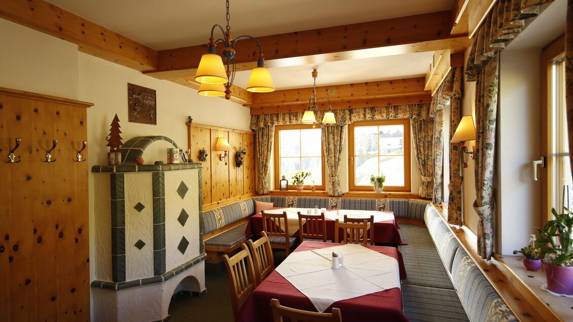 Ein gemütlicher Raum mit Holzwänden und großen Fenstern. Tische und Bänke laden zum Verweilen ein, ideal für gesellige Runden. | © Herbert Raffalt